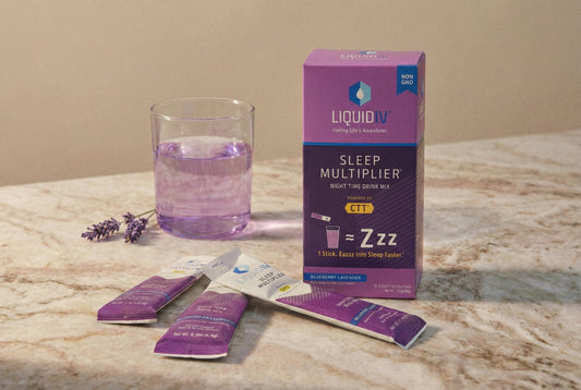 A pack of liquid iv sleep multiplier next to a glass.