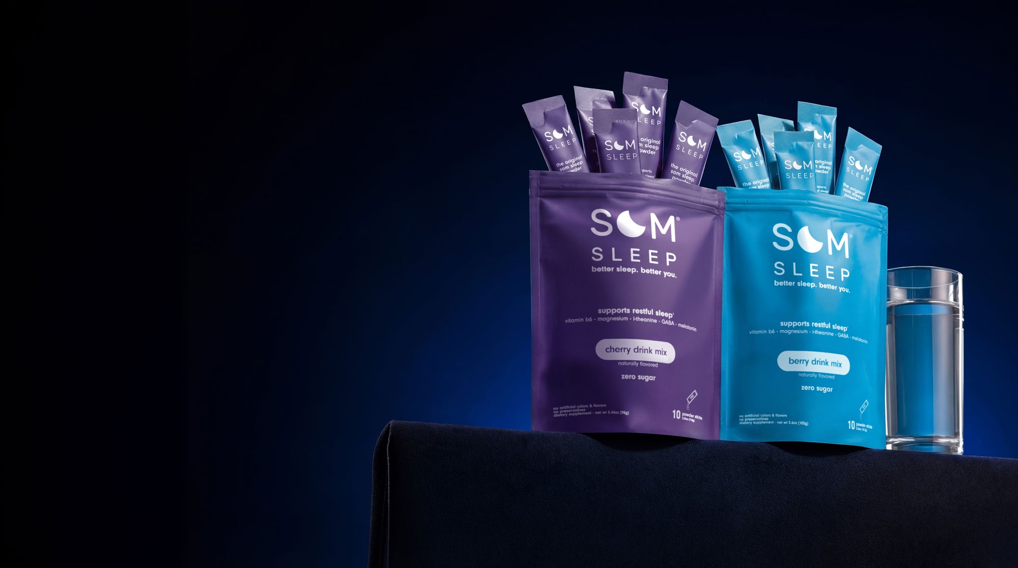 Som Sleep products including packets and a glass of water on a dark background